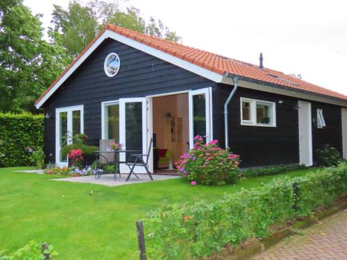 a small black house with a yard at Halte Liempde Logies in Liempde
