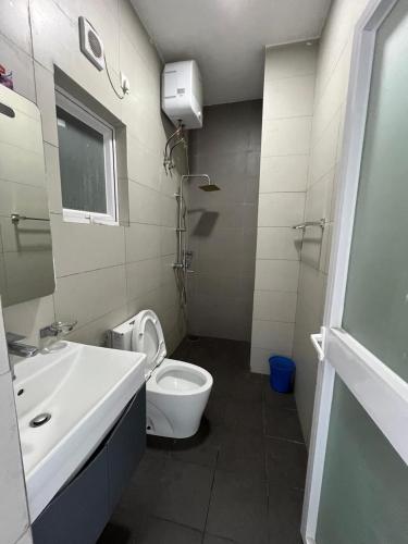 a bathroom with a white toilet and a sink at Blue Ocean in Dehiwala