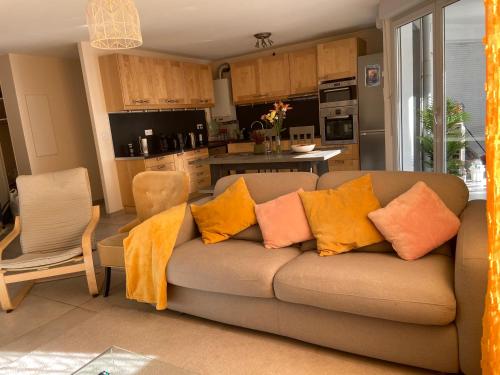 - un canapé avec des oreillers dans la cuisine dans l'établissement Appartement de standing - 3 chambres - 8 personnes - Grand Lyon, à Villeurbanne