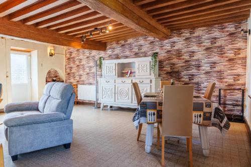 un salon avec un canapé bleu et une table dans l'établissement Gîte du Manoir, à Saint-Germain-des-Champs