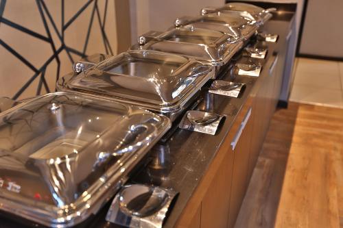 een rij pannen op een fornuis bij Inani Hotel Morning Star in Pretoria