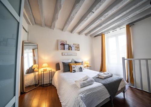une chambre avec un grand lit et un miroir dans l'établissement Joséphine Cosy - Centre Ville-Pets friendly - Home cinema Netflix - Jardin Privé, à Rueil-Malmaison