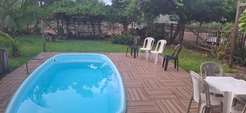 a backyard with a swimming pool and chairs and a table at Espaço Sairé - 8 minutos da Praia in Alter do Chao