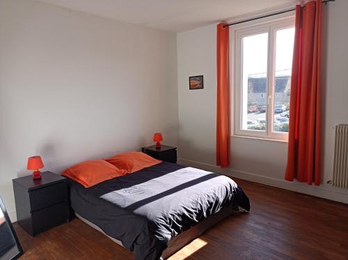 une chambre avec un lit et une fenêtre avec des rideaux rouges dans l'établissement Gîte de la fontaine, à Venarey-les-Laumes