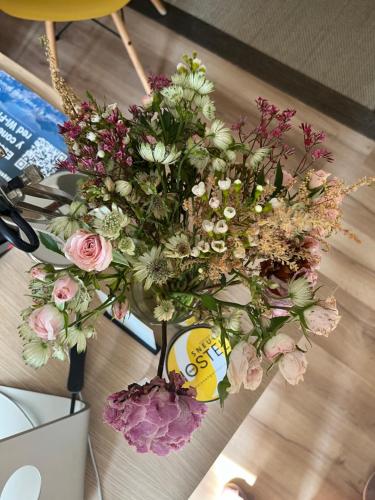 a bouquet of flowers in a vase on a table at Pension Angelines, Sneuu Hostel Santander in Santander
