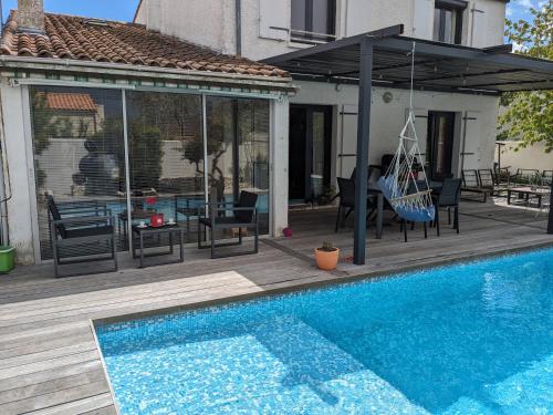un patio avec une balançoire et une piscine dans l'établissement Teresa Beauté - maison 3 chambres - 6 pers - proche La Rochelle, à Périgny
