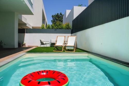 a red lifebuoy in a swimming pool next to a house at Villa Verde Priv Pool, 10min beach, near Lisbon in Amora