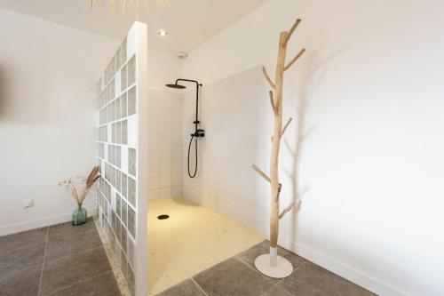 a bathroom with a shower with a tree in it at Villa Maya in Tendu
