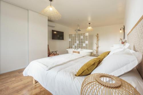 a white bedroom with a large bed and a sink at Villa Maya in Tendu