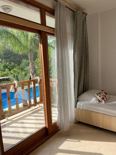 ein Schlafzimmer mit Fenster und Blick auf einen Balkon in der Unterkunft Yonca Hotel in Adrasan