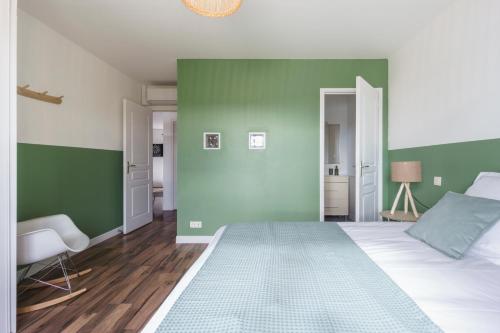 a bedroom with green and white walls and a bed at Villa Maya in Tendu