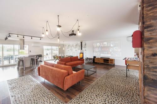 a living room with two orange chairs and a table at Villa Maya in Tendu
