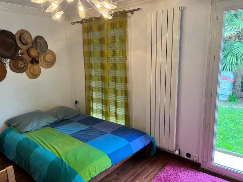 a bedroom with a bed and a large window at Villa Rémy in Champigny-sur-Marne