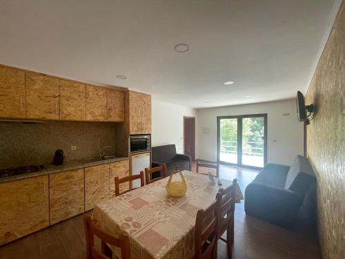 a kitchen and dining room with a table and a blue couch at Quinta de Fundões in Geres