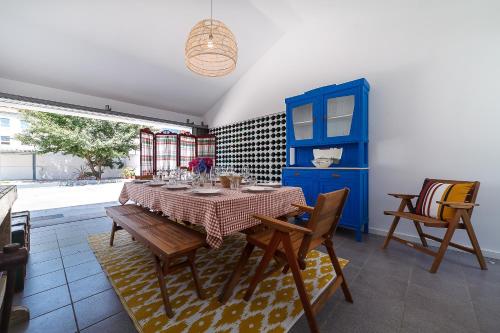 a dining room with a table and chairs and a blue cabinet at Villa Mau Maria incl Parking by Home Sweet Home Aveiro in Aveiro