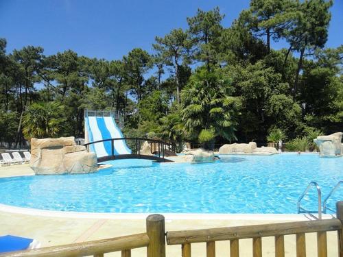 une grande piscine avec un toboggan aquatique dans l'établissement Mobil Home Confort G 07, à Saint-Georges-de-Didonne