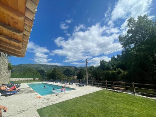 a swimming pool with people in a resort at Quinta de Fundões in Geres