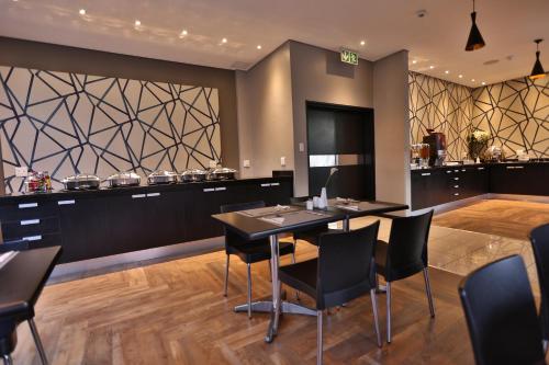 een eetkamer met een tafel en stoelen bij Inani Hotel Morning Star in Pretoria