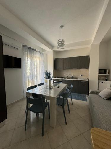 a kitchen and living room with a table and chairs at Amunì in terrazza in Porto Empedocle