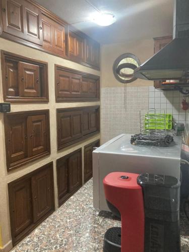 a kitchen with wooden cabinets and a red stool at SA FraDa in Olmedo
