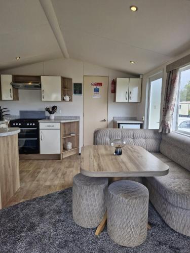 a living room with a table and a kitchen at Haven Skegness 20 Donna Nook in Skegness