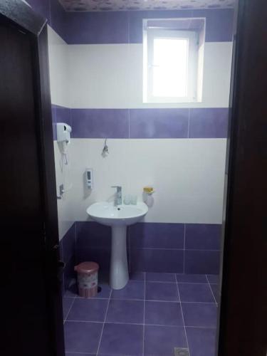 a blue and white bathroom with a sink and a window at Qafqaz White Palace in Gabala