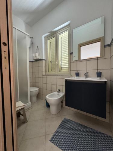 un bagno con lavandino, water e specchio di Amunì in terrazza a Porto Empedocle