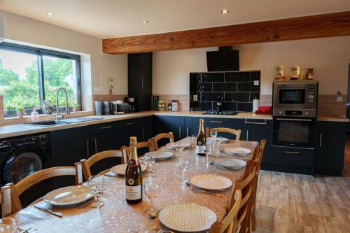 - une cuisine avec une table et des bouteilles de vin dans l'établissement Gites O'Simba et chez les tontons, à Savigny-Poil-Fol