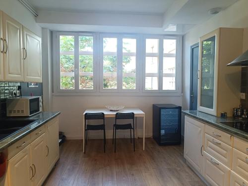 une cuisine avec une petite table et deux chaises dans l'établissement T3 PLAGES - Parking - Clim, à Toulon