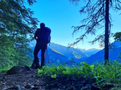 a man standing on a trail looking at the mountains at Camere Nordest Sudest- Conca Agordina in Agordo
