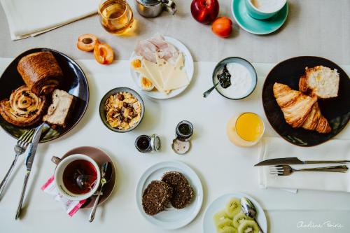 a white table topped with plates of food and drinks at Grand Hotel Des Bains & Villas des Bains in Vals-les-Bains