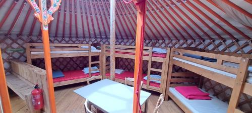 a room with three bunk beds in a yurt at La Petite Echelle in Rochejean