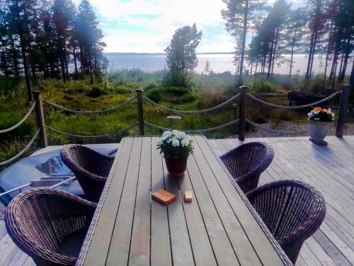 a wooden table with chairs and a potted plant on a deck at Havsnära villa in Nordmaling