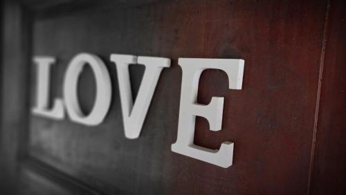 a wooden sign with the word joy written on it at Casa l'Acerone in Pian degli Ontani