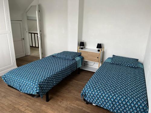 Zimmer mit 2 Betten, einer Kommode und einem Spiegel in der Unterkunft La maison de la brasserie in Sens