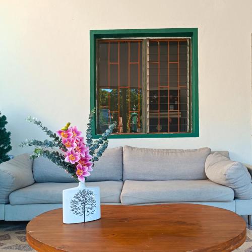 a living room with a couch and a table with flowers at Casa de Verano in La Pintada