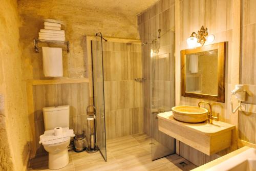 a bathroom with a sink and a shower and a toilet at Solin Cave Cappadocia in Mustafapaşa