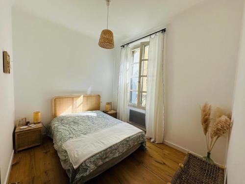 une chambre avec un lit et une fenêtre dans l'établissement Appartement au cœur de l'Ecusson, à Nîmes