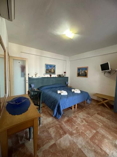 a bedroom with a blue bed and a table at Isoladelmiele in Marettimo