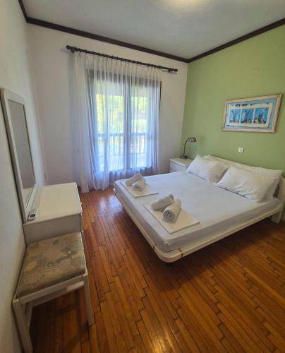 a bedroom with a large white bed and a window at GeoVilla Green & Blue 2 - Pefkochori in Pefkochori