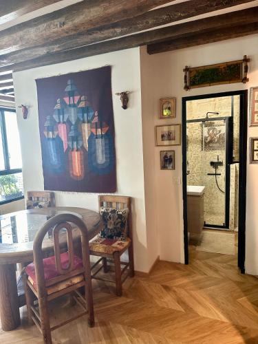 une salle à manger avec une table et un tableau au mur dans l'établissement Appartement cosy, à Paris