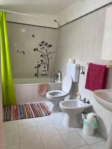 ein Badezimmer mit Toilette, Waschbecken und Badewanne in der Unterkunft Villa Atlantica Apartments in Angra do Heroísmo