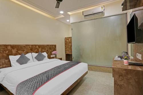 a bedroom with a large bed and a tv at Hotel O Kiwi International in Mumbai