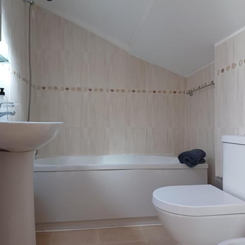 a bathroom with a tub and a toilet and a sink at Residencialusobrasileira in Leça da Palmeira