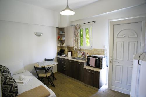 a small kitchen with a sink and a microwave at Enjoy Cyclades studios & suites in Kithnos