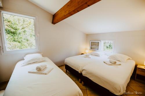 due letti in una stanza con due finestre di Domaine des Bains a Vals-les-Bains