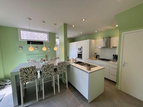 une cuisine avec des murs verts et une table et des chaises dans l'établissement Charmante Maison avec 3 places de parking, à Le Touquet-Paris-Plage