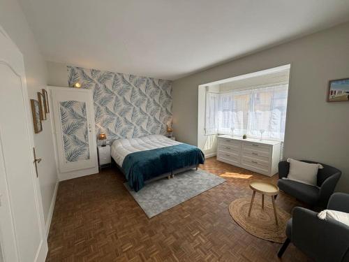 une petite chambre avec un lit et une chaise dans l'établissement Charmante Maison avec 3 places de parking, à Le Touquet-Paris-Plage