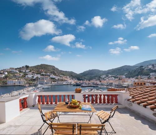 a patio with a table and chairs on a balcony at Douskos Exclusive Property in Hydra