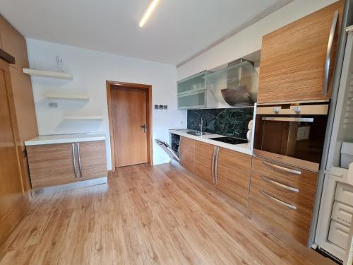 a large kitchen with wooden cabinets and wooden floors at Der Kristall by Globalimmoservice in Bad Kleinkirchheim